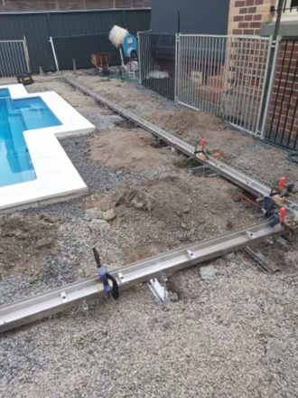 Trench drain being installed around a pool.